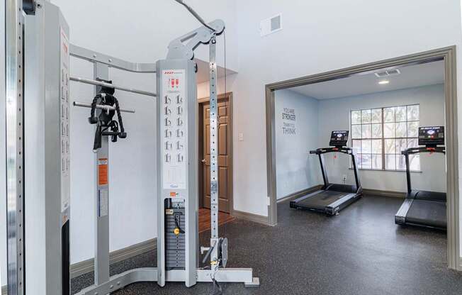 A gym with treadmills and a weight machine.