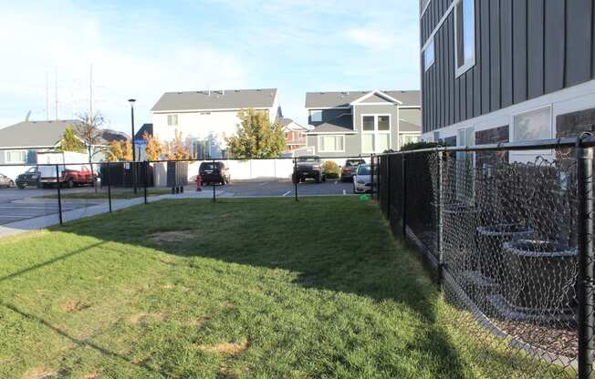 a yard with a chain link fence in front of a building