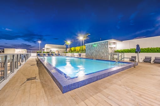 a swimming pool on the rooftop of a hotel at night