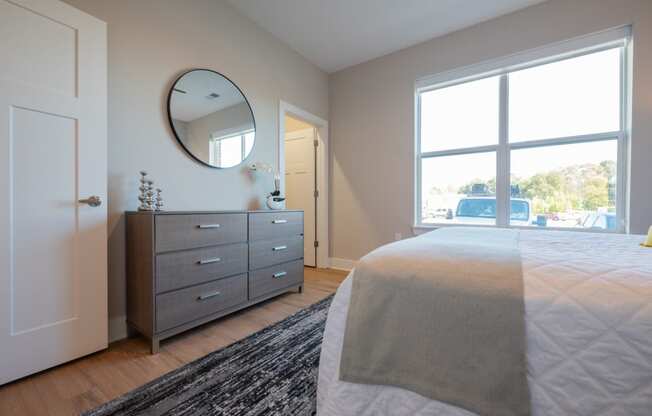 a bedroom with a bed and a dresser and a window