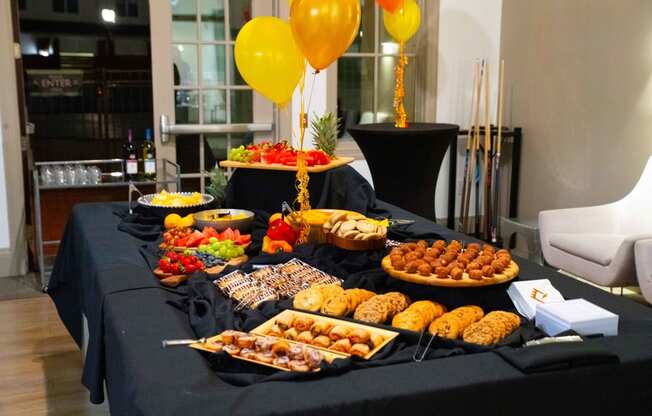 a buffet of food on a table with balloons