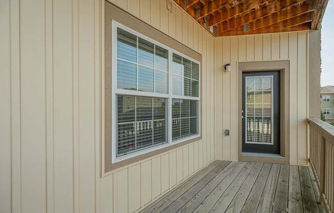 the front porch of a home with a door and windows