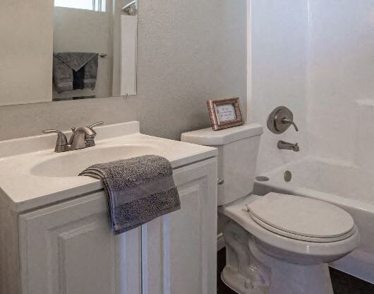 a white bathroom with a toilet and a sink