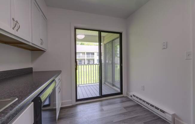 an empty kitchen with a door to a balcony