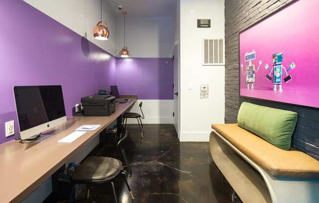 a workspace with two computers and a bench with a green pillow at Abberly Noda Vista Apartment Homes, Charlotte, NC, 28206