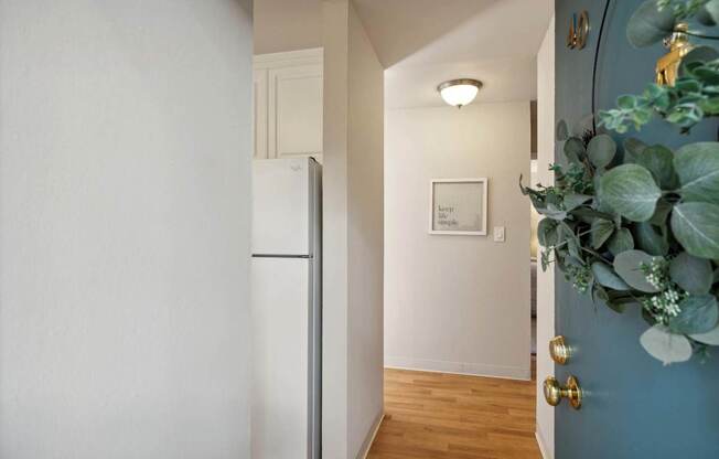 A hallway with a white door and a blue wall.