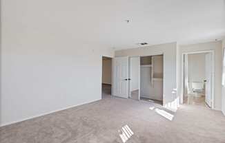 an empty living room with white walls and a bathroom at Dronfield Astoria, Sylmar, California