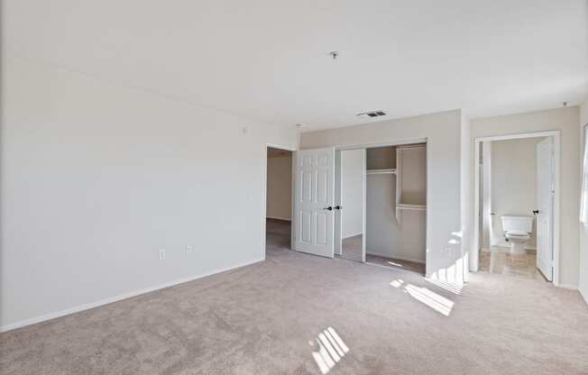 an empty living room with white walls and a bathroom at Dronfield Astoria, Sylmar, California