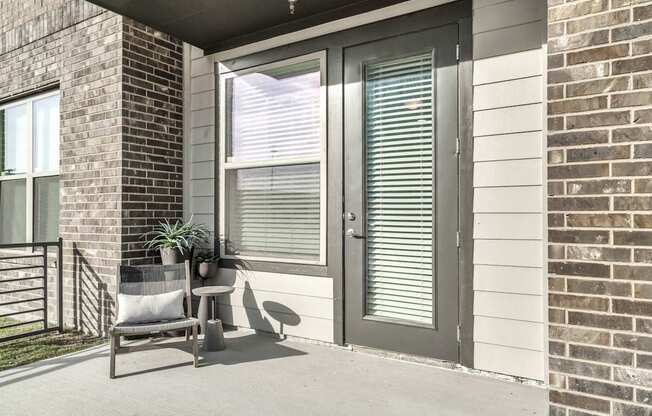 A patio with a chair and a potted plant.