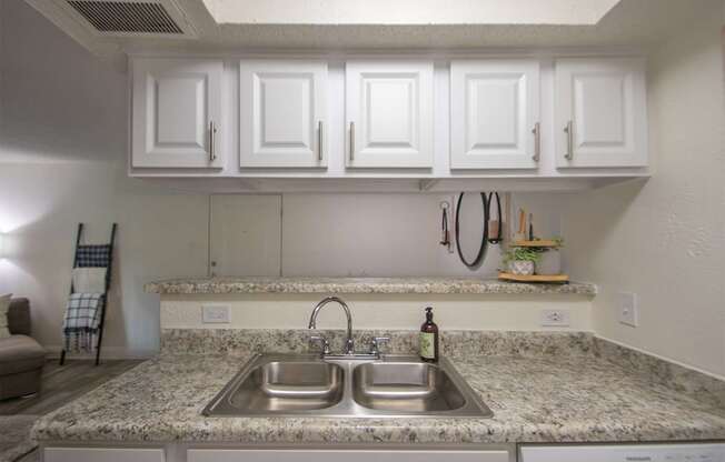 View of the dining room from the kitchen of a 515 square foot 1 bedroom, 1 bath apartment home at Canyon Creek Apartments in Dallas Midtown neighborhood of Dallas, TX.