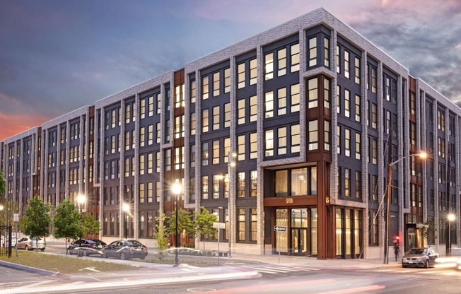 A modern multi-story building with a parking lot in front.