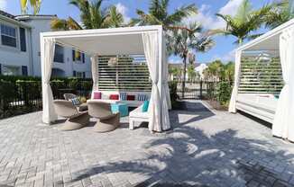 a patio with two chairs and a table under a canopy