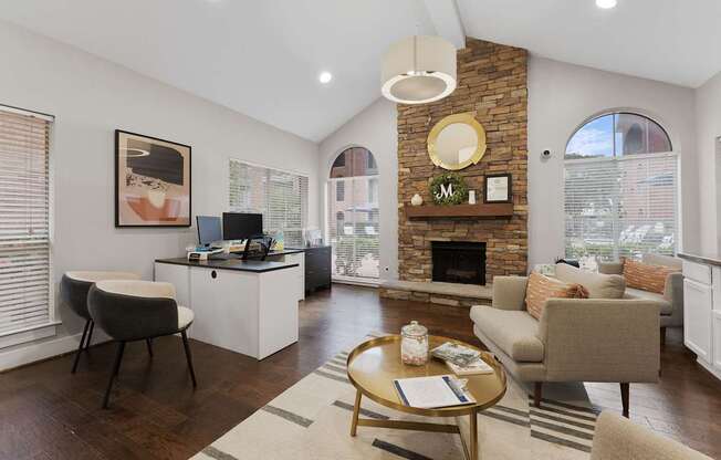 A cozy living room with a fireplace and a desk area.