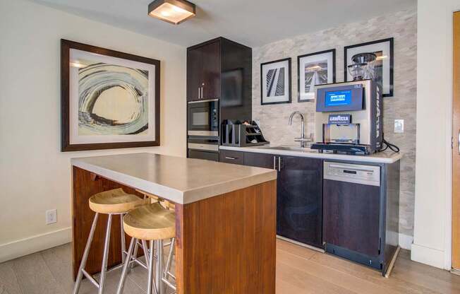 A kitchen with a bar stool and a fridge.