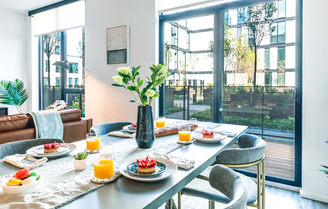 A breakfast table set with plates of food and glasses of orange juice.
