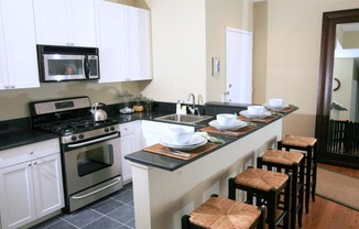Newark Apartments-Eleven80 Apartments Kitchen With Split Square Tile And Wood-Style Flooring And Breakfast Bar With Seating