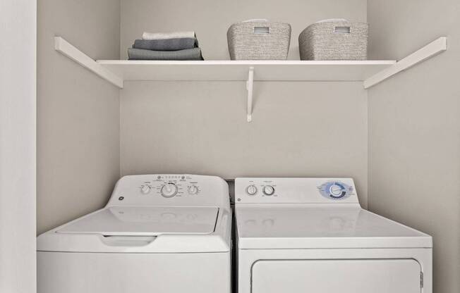 Two white washing machines in a laundry room.