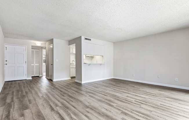 an empty living room with white walls and wood flooring