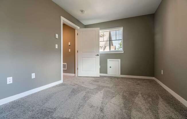 A room with a carpeted floor and a doorway leading to another room.
