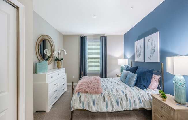 a bedroom with a bed and a dresser and a window