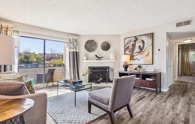 A living room with a fireplace and a painting on the wall.