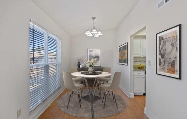 a dining room with a table and chairs and a large window