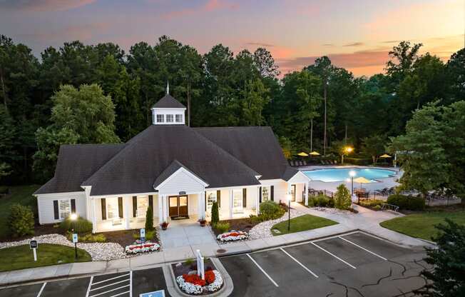 an aerial view of a building with a swimming pool in the background