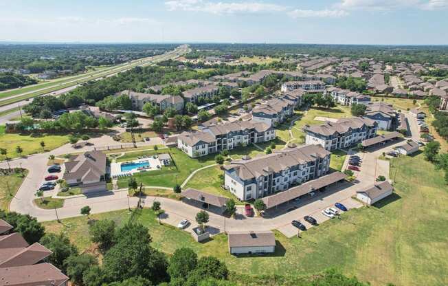 an aerial view of an apartment complex with houses and a parking lot