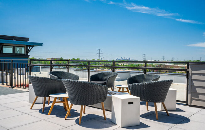 a rooftop terrace with chairs and tables on a sunny day