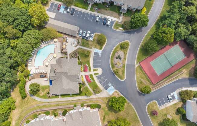 arial view of a house with a swimming pool and tennis court