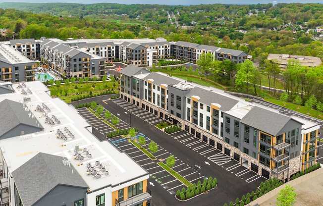 an aerial view of a development of apartments with parking lot and trees