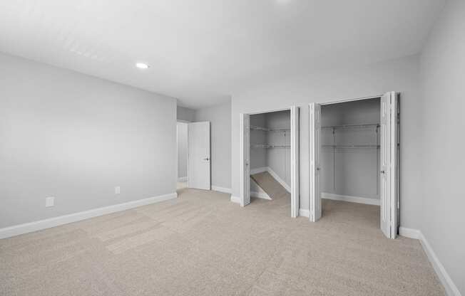 a room with a carpeted floor and a closet with mirrored doors