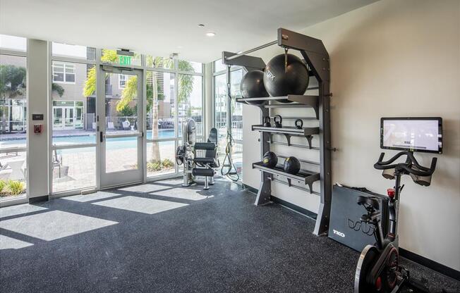 a workout room with a bike and a tv