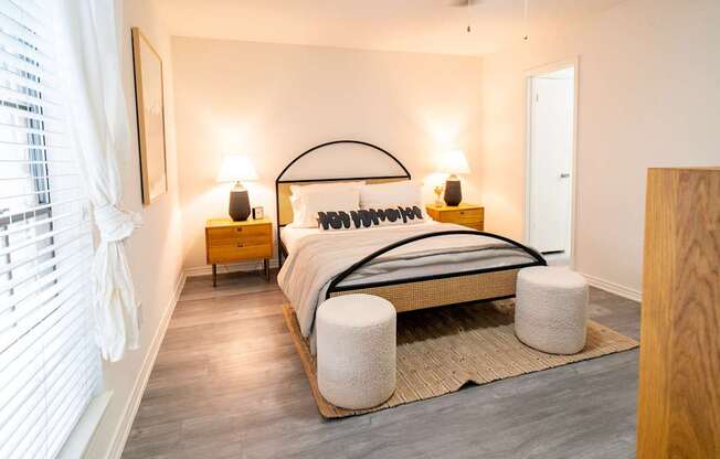 A bedroom with a bed, nightstands, and a rug.