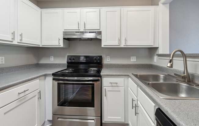 a kitchen with white cabinets and stainless steel appliances