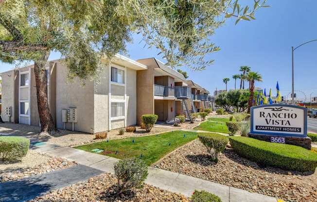 A Rancho Vista Apartments sign is in front of a building with a landscaped yard.