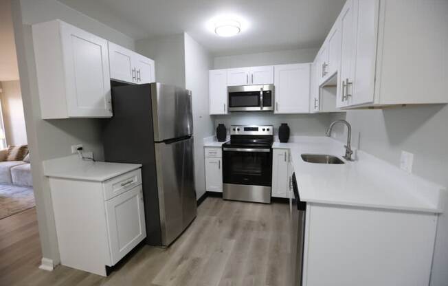 A kitchen with white cabinets and stainless steel appliances. at Evergreen, Merrillville