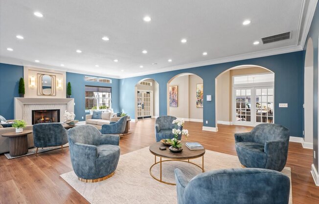 A living room with a fireplace and blue chairs.