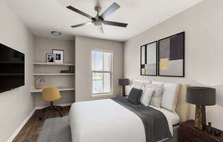 A bedroom with a bed, a desk with a chair, and a ceiling fan.