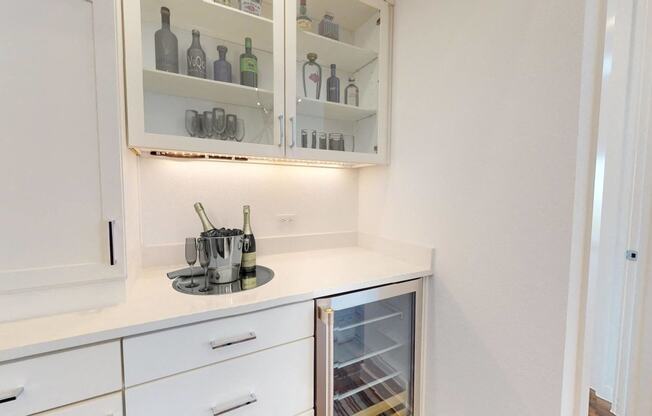 a small kitchen with white cabinets and white counter tops and a white counter top refrigerator