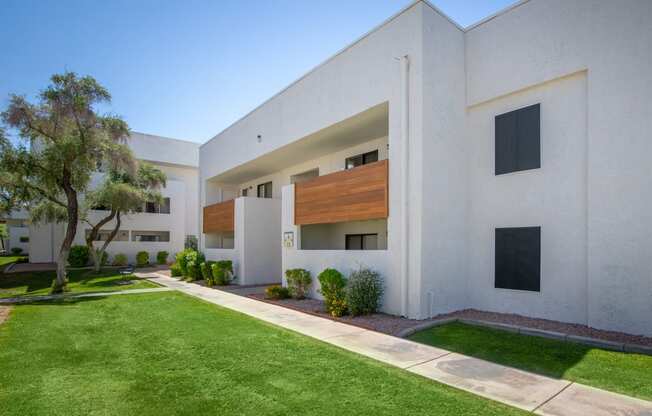 a large white building with a green lawn in front of it