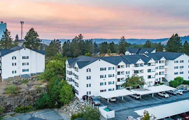 A large white building with a parking lot in front of it.