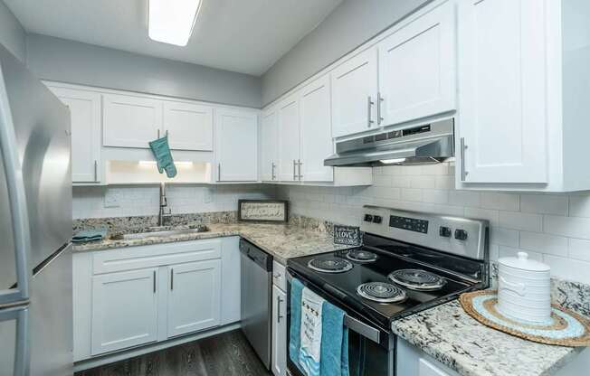 A kitchen with a stove top oven and a refrigerator.