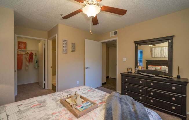 A bedroom with a bed, dresser, and mirror at Sterling Point Apartment Homes, Phoenix, Arizona