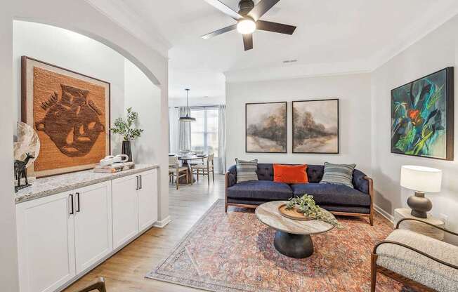 A living room with a couch, a coffee table, and a painting on the wall.