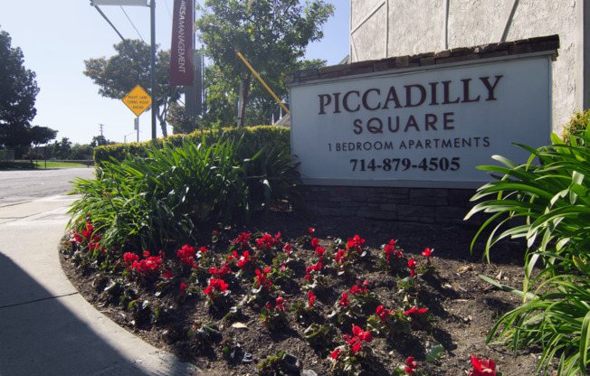 A sign for Piccadilly Square Bedroom Apartments is in front of a building.