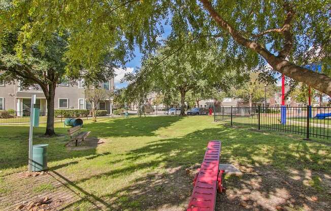 a park with a red picnic table and benches at Sladestone Shadow Creek, Pearland, TX