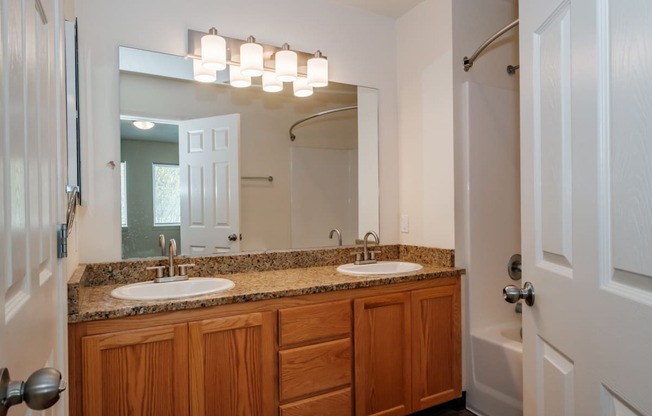 a bathroom with two sinks and a shower