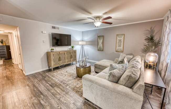 a living room with a couch and a ceiling fan