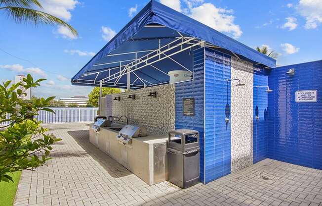Grilling station with bbq grills and a showerhead at Blue Lagoon 7 apartments in Miami FL